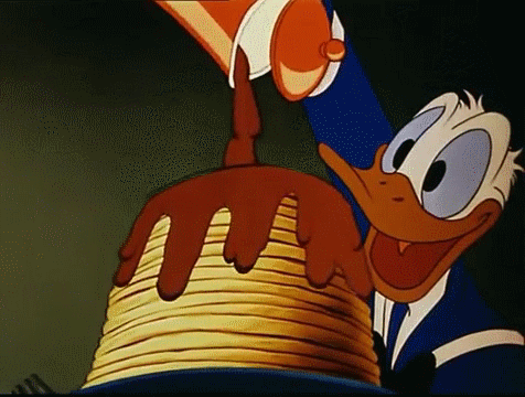 I dolci nei cartoni: Paperino versa lo sciroppo d'acero su una pila di Pancakes