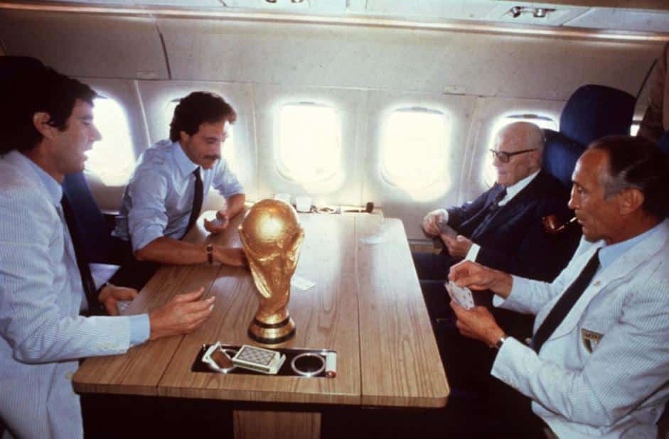 Italia Campione del Mondo: Il presidente Sandro Pertini, i calciatori Causio e Zoff Italian e il CT Enzo Bearzot giocano a scopone sul volo di ritorno. Sul tavolo la coppa del mondo.