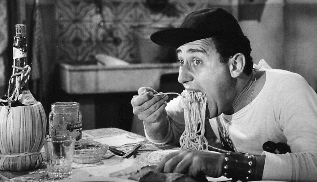 Alberto Sordi alle prese con il celebre generoso boccone di spaghetti in "Un Americano a Roma" diretto da Steno nel 1954.