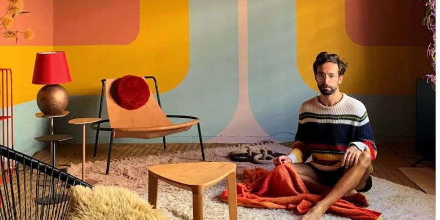 Come si Progetta il colore dei muri di una casa? michell lott. in primo piano con propria opera murale alle spalle